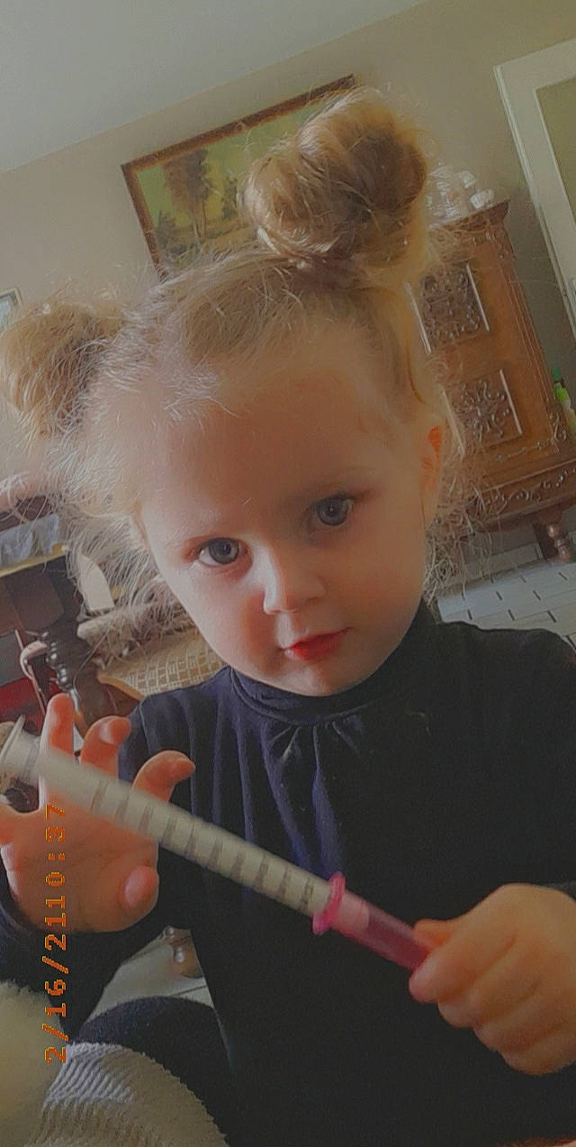 Jade a rejoint le concours — aidez-le/la à gagner de superbes lots ! baby, baby_toddler_clothing, blond, chair, cheek, child, finger, headband, headpiece, office_supplies, person, room, sitting, t_shirt, thumb, toddler, writing, writing_instrument_accessory