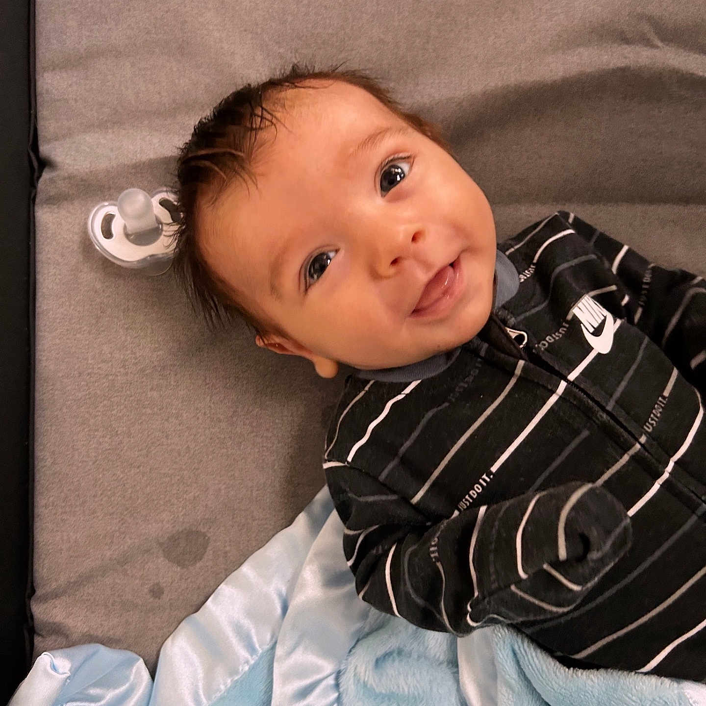 Nicholaus is registered to the contest to win money with this photo: baby, blanket, bodypart, clothing, crib, cushion, face, finger, furniture, happy, head, homedecor, infantbed, newborn, pants, person, photography, portrait, shirt, smile