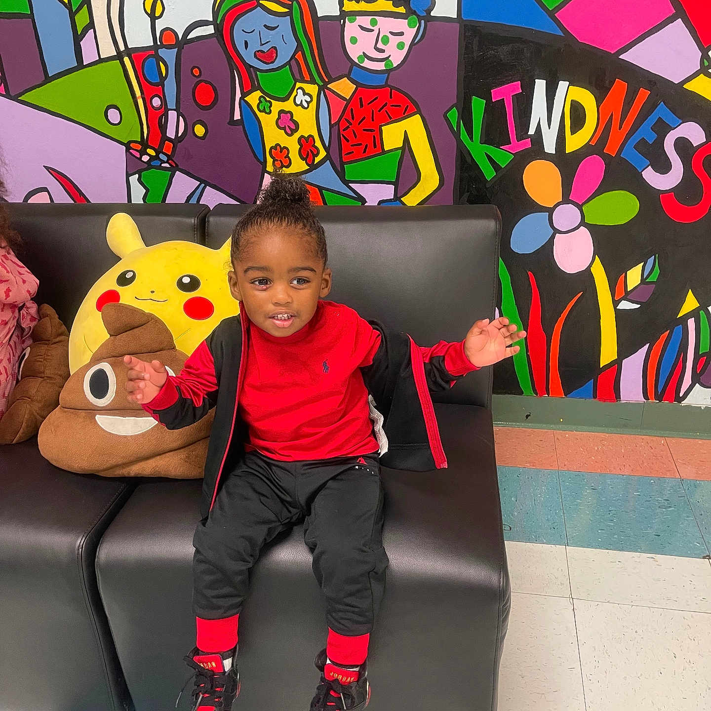 Jamar is registered to the contest to win money with this photo: black_couch, black_hair, casual_wear, child, colorful_mural, cute, floor_tiles, happy, indoor, kindness_text, person, pikachu, playful, plush_toys, poop_emoji_pillow, red_clothing, sitting, smiling, sneakers, wall_art