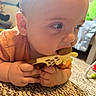 Oliver is registered to the contest to win money with this photo: baby, infant, child, face, eyes, hands, teether, toy, giraffe, chewing, curious, orange_clothing, portrait, close_up, indoor, home, rug, carpet, soft_lighting, sitting