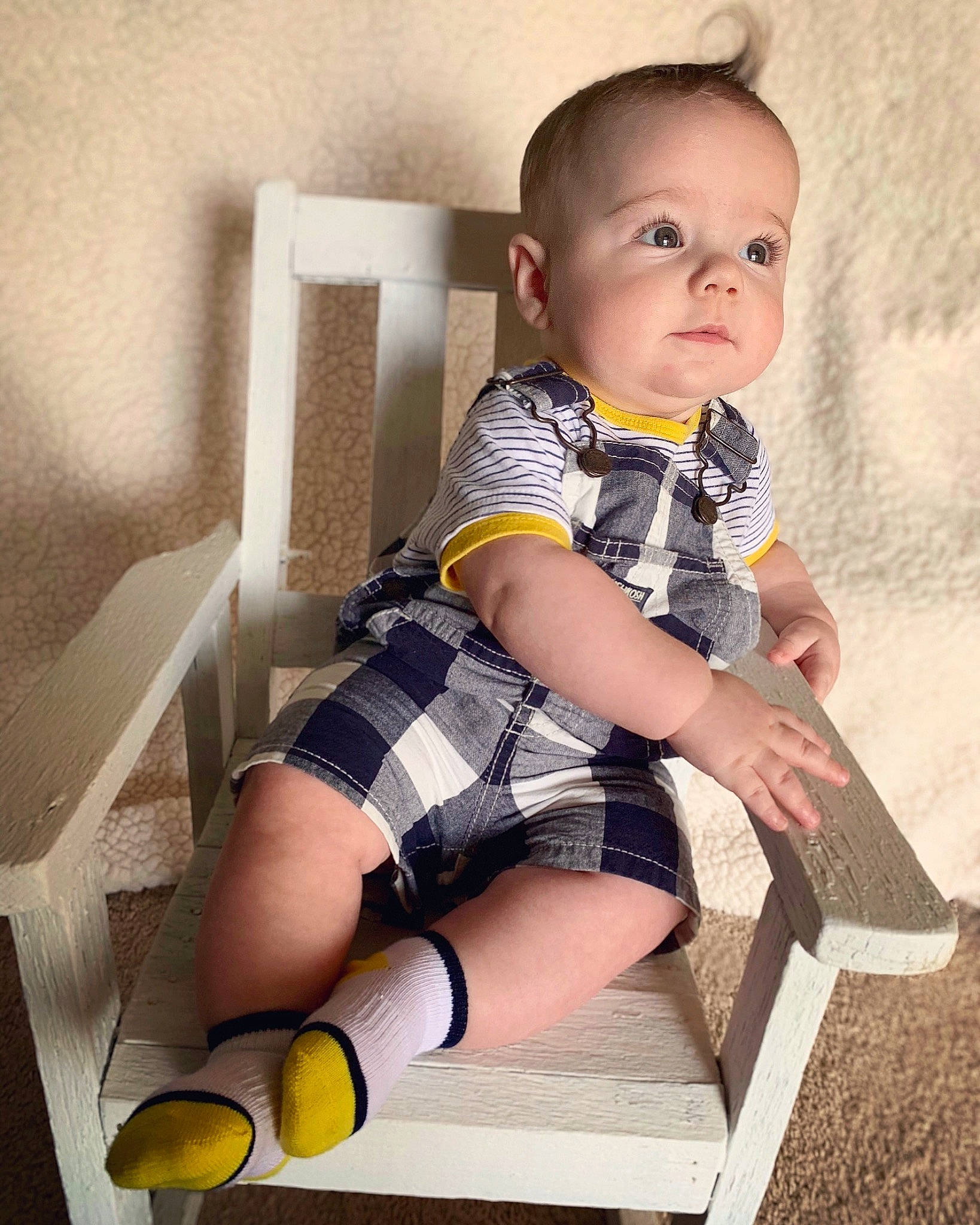 Duke is registered to the contest to win money with this photo: baby, child, child_model, design, eye, human_leg, joint, knee, leg, pattern, person, plaid, shoe, sitting, stock_photography, thigh, toddler, uniform, yellow