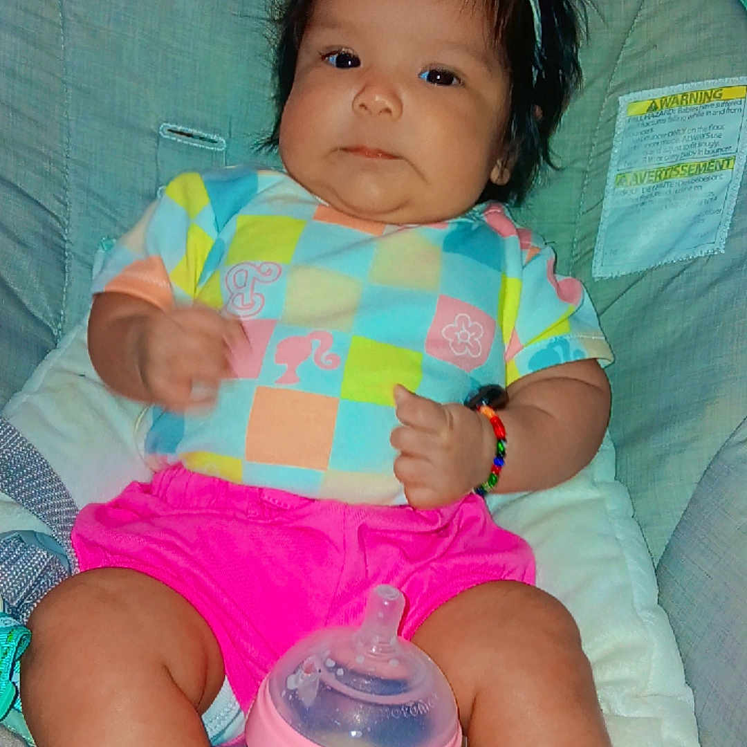 Ma'Lyzza joined the competition — help win amazing prizes! baby, baby_seat, bottle, bow, bracelet, child, chubby_legs, colorful_clothing, cute, expression, face, headband, indoor, infant, person, pink_shorts, resting, seat_belt, socks, young_child