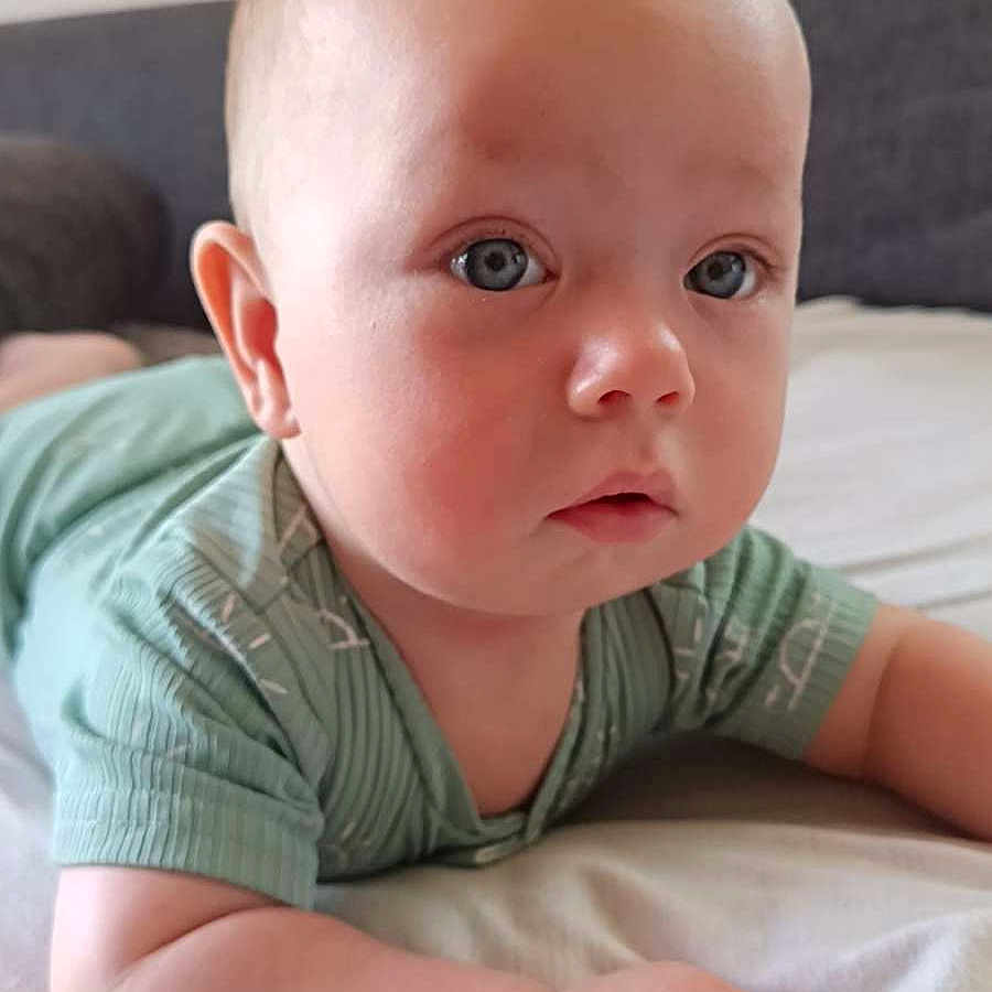 Ethan a rejoint le concours — aidez-le/la à gagner de superbes lots ! arms, baby, bed, blanket, blue_eyes, child, close_up, couch, curious, face, fists, head, indoors, infant, mint_green_clothing, portrait, resting, skin, soft_light, young