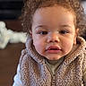 Malakhi is registered to the contest to win money with this photo: baby, blanket, bokeh, cheeks, child, closeup, clothing, curiosity, curly_hair, cute, eyes, face, hoodie, indoors, lips, portrait, sherpa_vest, toddler, wood_floor, zipper