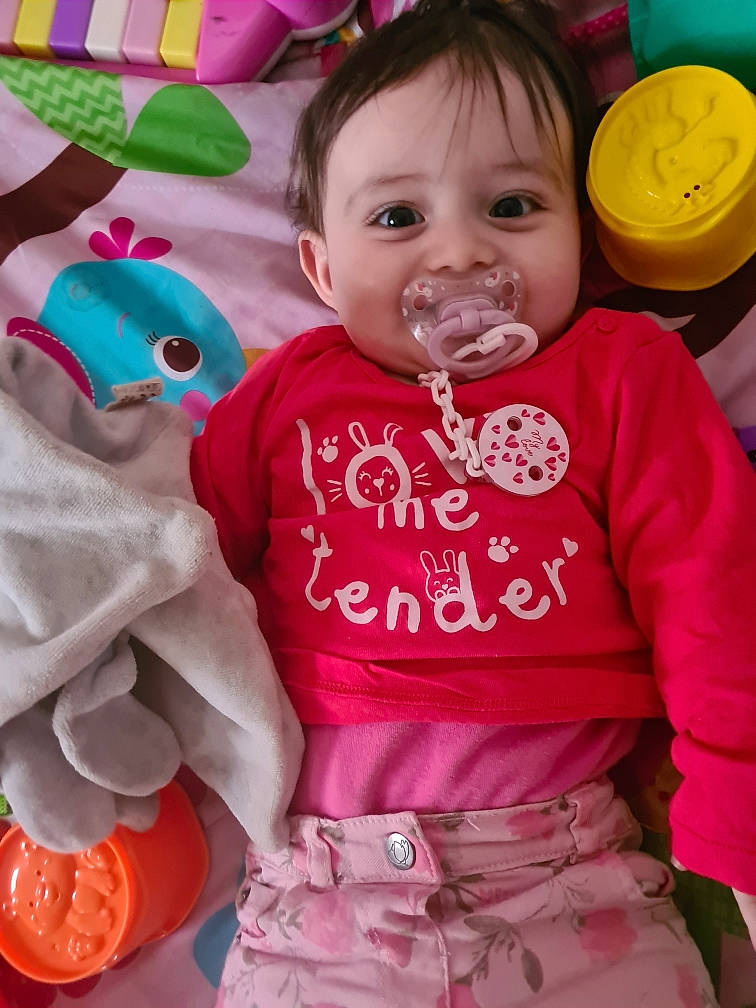 Anais a rejoint le concours — aidez-le/la à gagner de superbes lots ! baby, baby_toddler_clothing, cheek, face, facial_expression, green, hairstyle, happy, joy, orange, organ, outerwear, person, pink, red, skin, sleeve, smile, t_shirt, textile