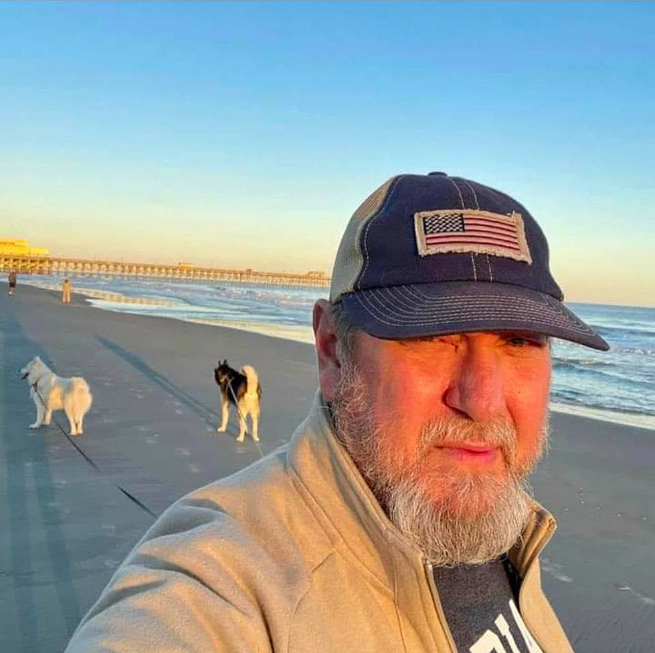 Lobo N Posey is registered to the contest to win money with this photo: baseball_cap, beach, beard, cap, carnivore, coast, dog, dog_breed, facial_hair, fawn, horizon, landscape, moustache, sand, shore, sky, travel, vertebrate, water, winter