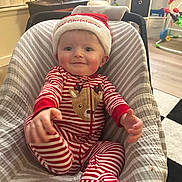 Kai is registered to the contest to win money with this photo: baby, infant, child, smiling, christmas_hat, striped_pajamas, reindeer, baby_seat, cushion, indoor, holiday, festive, cute, cheerful, smile, person, young_child, home, soft_lighting, decorations