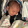Delilah is registered to the contest to win money with this photo: baby, infant, sleeping, car_seat, seatbelt, blanket, hood, floral_clothing, portrait, indoors, resting, peaceful, eyes_closed, head, face, child, cozy, textile, travel, nap