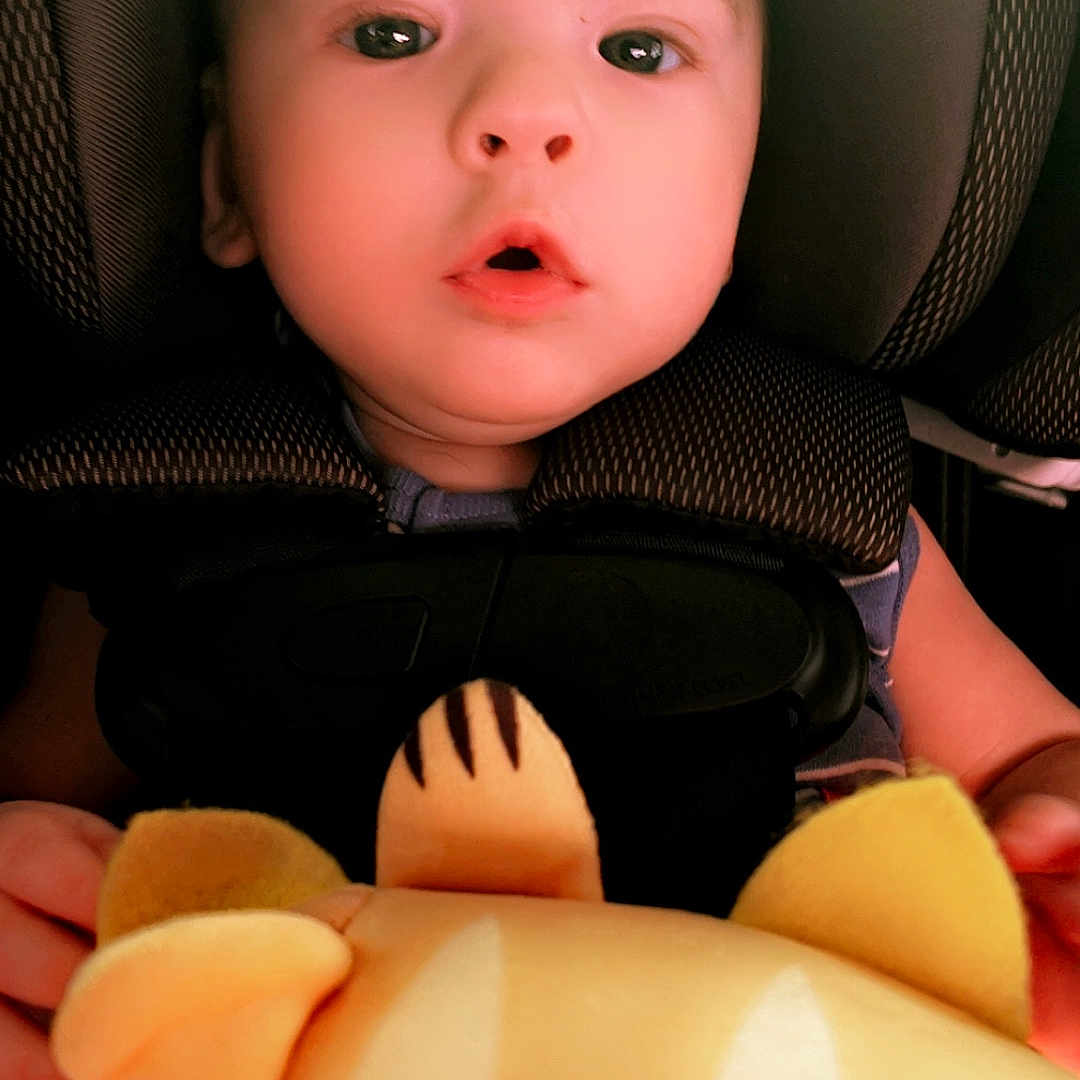 Kaydon is registered to the contest to win money with this photo: baby, bodypart, car, car_interior, carseat, clothing, couch, cushion, face, finger, furniture, hand, head, headrest, homedecor, person, photography, portrait, transportation, vehicle