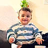 toddler, child, smile, striped_hoodie, couch, plant, indoor, portrait, happy, cozy, home, furniture, painting, wall, person, seated, casual, young_child, cute, living_room