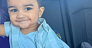 Augustine is registered to the contest to win money with this photo: toddler, child, smile, car_seat, blue_shirt, beige_pants, bracelet, short_hair, happy, portrait, indoor, seat, person, casual_clothing, young_child, cute, baby, vehicle_interior, head, face
