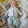 baby, infant, smiling, vest, pants, blanket, polka_dot, dimple, lying_down, cute, child, happy, face, clothing, fabric, soft, comfort, indoor, person, portrait