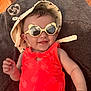 baby, child, sunglasses, hat, orange_clothing, smile, towel, sunlight, palm_tree_pattern, relaxing, infant, cute, summer, outdoor, happy, portrait, baby_girl, skin, hand, face