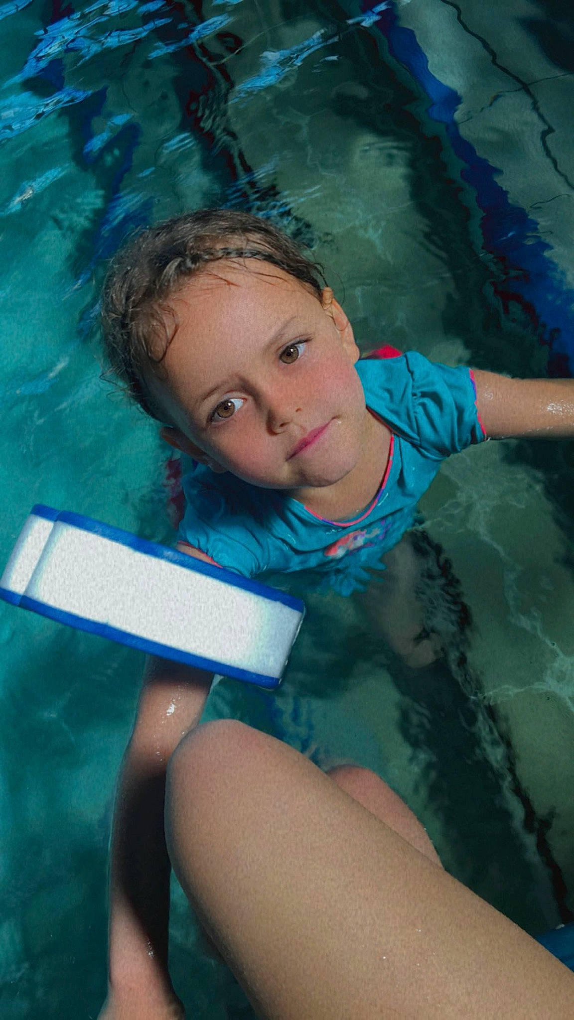 Mélina a rejoint le concours — aidez-le/la à gagner de superbes lots ! aqua, azure, bathing, black_hair, blue, child, electric_blue, eye, facial_expression, fun, happy, human_leg, leisure, person, recreation, summer, swimming_pool, thigh, toddler, water