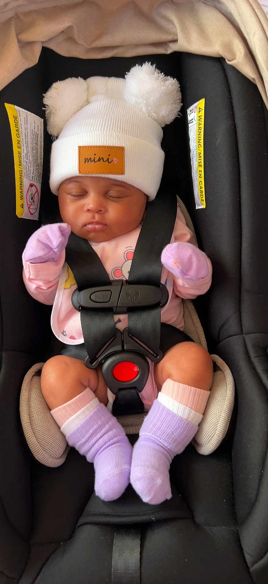 Khalila joined the competition — help win amazing prizes! baby, infant, car_seat, hat, pom_poms, sleeping, socks, mittens, safety_harness, black, pink_clothing, closeup, cute, child, newborn, seat_belt, soft, cozy, indoor, peaceful