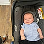 baby, car_seat, smile, infant, striped_shirt, blue_and_white, black_pants, floor, wooden_floor, footwear, sandals, indoor, happy, person, child, seat, seatbelt, cabin, cute, casual