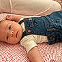 baby, infant, denim_overalls, white_shirt, polka_dot, blanket, laying, face, skin, head, expression, cute, child, indoor, portrait, soft_light, cozy, relaxed, human, newborn