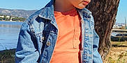 Nino a rejoint le concours — aidez-le/la à gagner de superbes lots ! child, boy, denim_jacket, orange_shirt, ripped_jeans, rock, tree, grass, lake, mountains, sky, outdoor, nature, casual_clothing, portrait, side_view, sunlight, young_person, relaxing, scenic