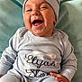 Elijah is registered to the contest to win money with this photo: baby, infant, smiling, laughing, hat, clothing, onesie, happy, cute, child, portrait, skin, hand, face, lying_down, fabric, soft, indoors, person, babywear