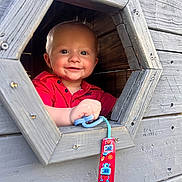 Maverick joined the competition — help win amazing prizes! baby, child, smiling, face, red_shirt, pacifier, wooden_playhouse, window, hand, blue_pacifier, toy, outdoor, play, happy, cute, infant, closeup, wood, hexagon, colorful