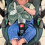 baby, sleeping, stroller, plush_toy, denim_overalls, striped_shirt, bare_feet, infant, child, car_seat, toy, cute, peaceful, indoor, floor_tiles, wheels, seatbelt, soft_toy, resting, toddler