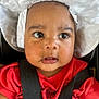 Alora is registered to the contest to win money with this photo: baby, child, face, hat, white_hat, red_shirt, car_seat, black_straps, wide_eyes, curious, close_up, infant, skin, young_child, portrait, seatbelt, cute, expression, headwear, indoors