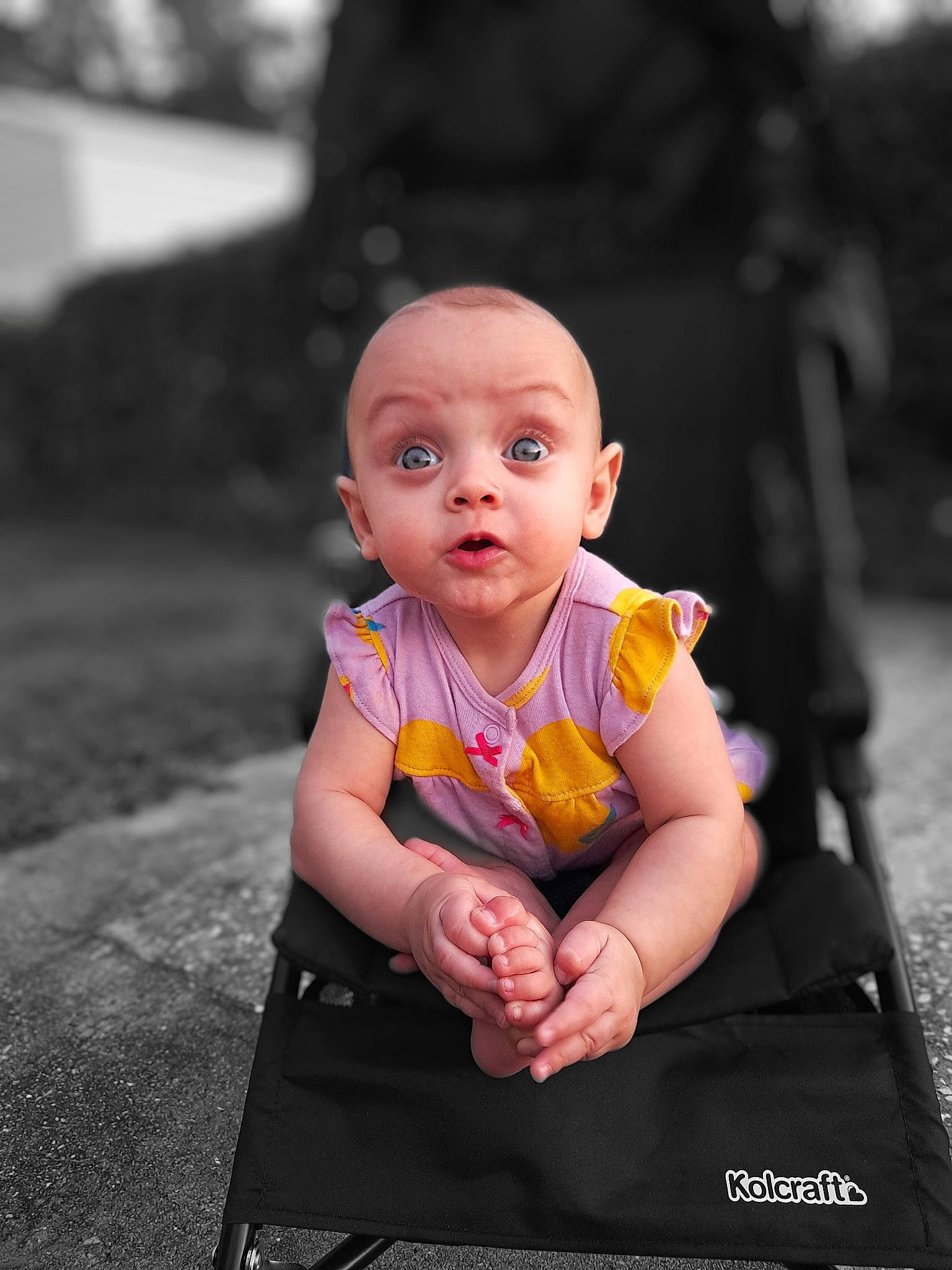 Amanda is registered to the contest to win money with this photo: asphalt, baby, baby_toddler_clothing, child, flash_photography, fun, gesture, grass, happy, leisure, magenta, monochrome_photography, person, portrait_photography, road, road_surface, sitting, smile, street, surprise
