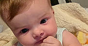 Sophia is registered to the contest to win money with this photo: baby, closeup, infant, child, redhead, face, hand, blanket, indoors, cute, young, expression, skin, eyes, clothing, sleeveless, person, portrait, soft, cozy