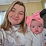 Sophia joined the competition — help win amazing prizes! woman, baby, baby_bow, pink_bow, headband, freckles, nose_ring, smile, face, portrait, indoor, clothing, white_sweater, baby_clothes, person, child, young_woman, closeup, parent_and_child, family