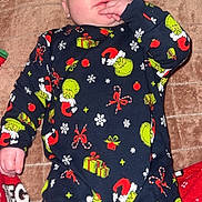 Livay participe au concours pour gagner de l'argent avec cette photo : baby, infant, pajamas, grinch, holiday, christmas, blanket, hand, face, sucking, cozy, lying_down, child, cute, festive, red, green, patterned_clothing, indoors, soft