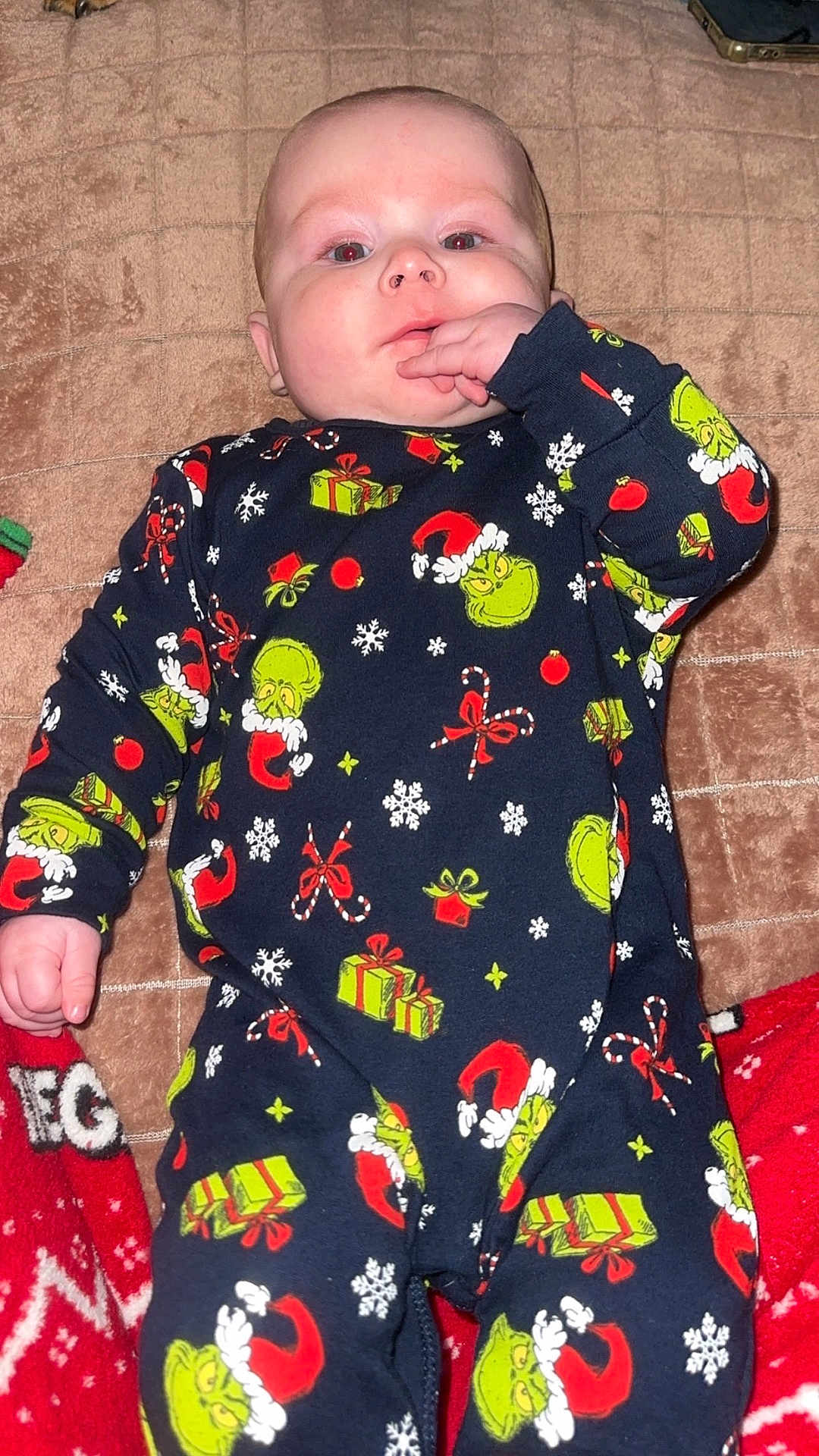 Livay participe au concours pour gagner de l'argent avec cette photo : baby, infant, pajamas, grinch, holiday, christmas, blanket, hand, face, sucking, cozy, lying_down, child, cute, festive, red, green, patterned_clothing, indoors, soft