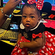 Ra'Mairie joined the competition — help win amazing prizes! baby, child, minnie_mouse, costume, red_bow, polka_dots, dress, hand, bracelet, tattoo, office, keyboard, computer_screen, sticky_notes, person, portrait, cute, indoor, young_child, face