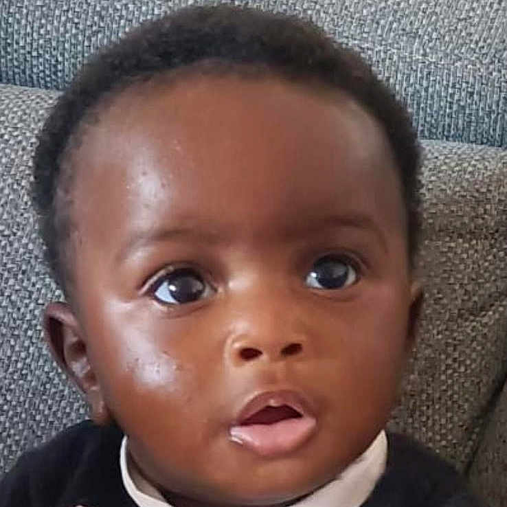 Isalys participe au concours pour gagner de l'argent avec cette photo : baby, black_hair, child, closeup, clothing, couch, curious, cute, expression, eyeballs, face, indoors, infant, looking, person, portrait, seated, sitting, skin, young_child