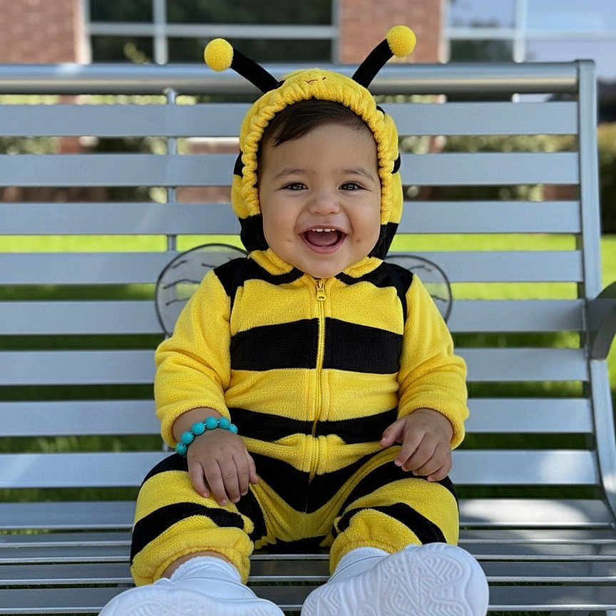 Liam joined the competition — help win amazing prizes! baby, bee_costume, bench, black, bracelet, child, costume, cute, footwear, happy, headgear, infant, outdoor, person, playful, portrait, sitting, smiling, white_shoes, yellow