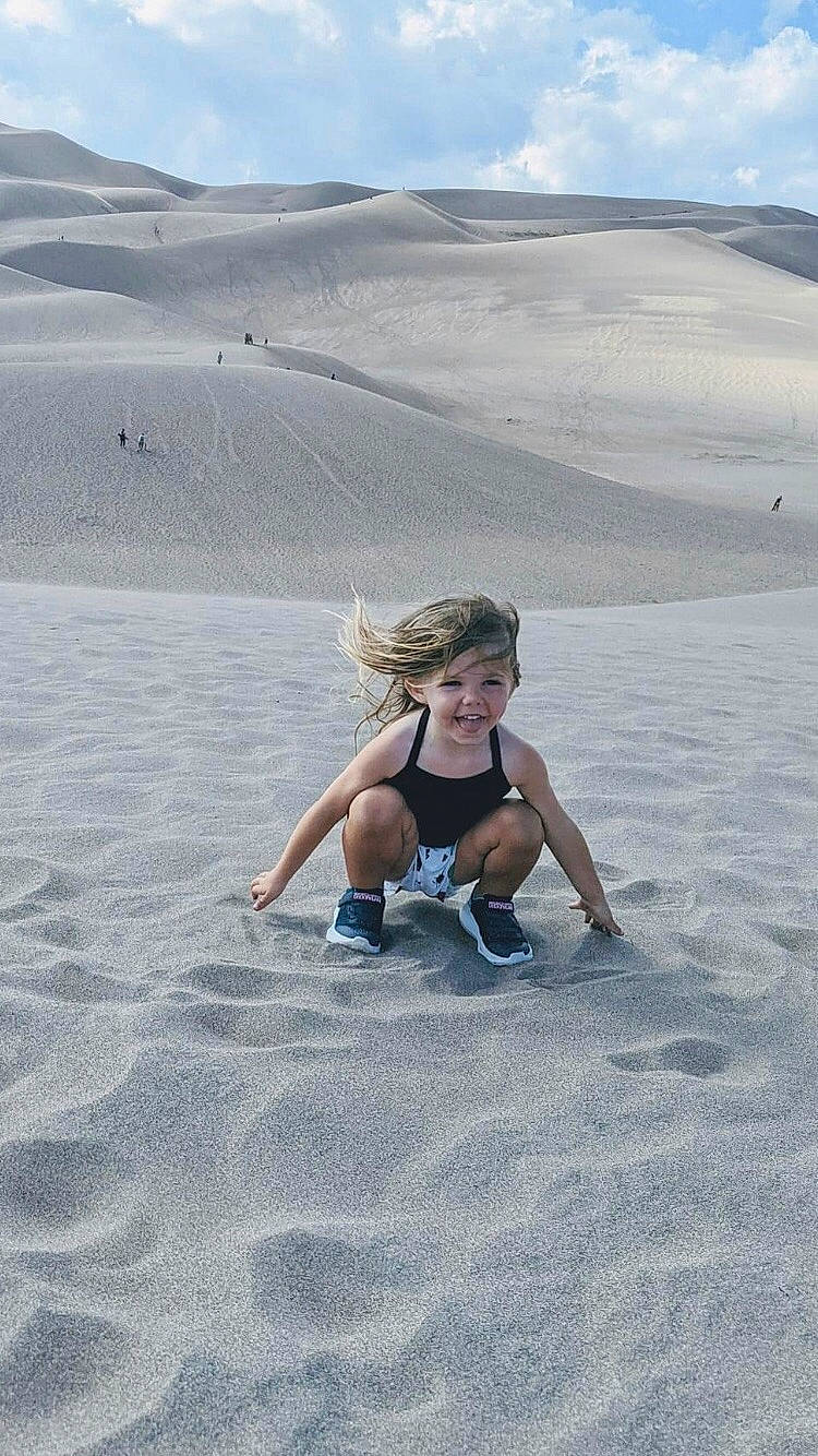 Marleigh is registered to the contest to win money with this photo: aeolian_landform, azure, body_of_water, cloud, dune, ecoregion, fun, grassland, happy, horizon, joy, landscape, mammal, mountainous_landforms, people_in_nature, person, plain, singing_sand, sky, summer