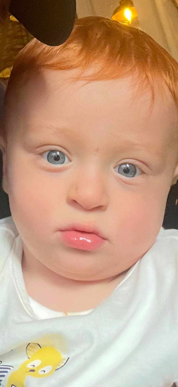 Lucien participe au concours pour gagner de l'argent avec cette photo : child, baby, face, blue_eyes, red_hair, white_shirt, cartoon_character, close_up, indoor, portrait, curious, pensive, soft_lighting, young_child, toddler, cute, expression, skin, head, person