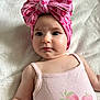baby, infant, child, pink_bow, headband, strawberry_print, pink_tank_top, cute, portrait, lying_down, soft_blanket, closeup, face, skin, eyes, arm, cute_expression, indoors, clothing, adorable