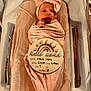 Josie joined the competition — help win amazing prizes! newborn, baby, infant, swaddled, pink, headband, hospital, bassinet, blanket, sign, birth_details, lying_down, cute, sleepy, wrapped, child, portrait, indoors, soft_lighting, peaceful
