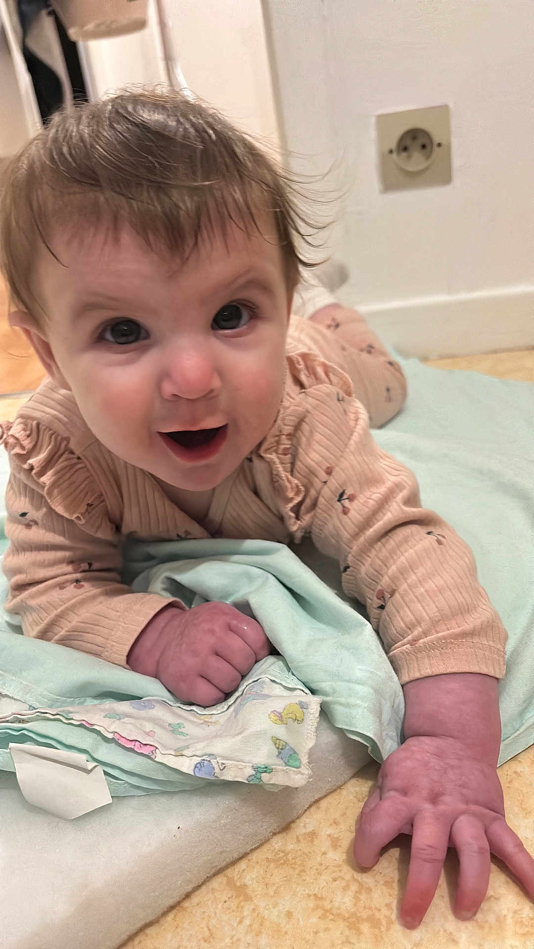 Albane participe au concours pour gagner de l'argent avec cette photo : baby, infant, child, cute, smiling, blanket, hand, face, eyes, hair, indoor, floor, clothing, pajamas, person, toddler, expression, skin, lying_down, curious