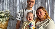 Rían is registered to the contest to win money with this photo: baby, background, basket, casual, child, clothing, curtain, family, flowers, happy, holding, indoor, man, parent, people, portrait, smile, sweater, together, woman