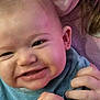 Milo participe au concours pour gagner de l'argent avec cette photo : baby, infant, smiling, close_up, face, hand, ear, mouth, cheeks, teeth, blue_clothing, fabric, cozy, indoor, partial_face, person, hair, portrait, playful, cuddling