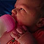 Octavia is registered to the contest to win money with this photo: baby, bottle, bottle_feeding, child, closeup, cute, face, feeding, hands, indoors, infant, newborn, orange_clothing, pink, portrait, resting, skin, sleepy, soft_light, young