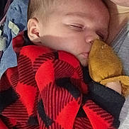 Octavia joined the competition — help win amazing prizes! baby, sleeping, infant, red_clothing, plaid, mitten, close_up, person, cuddle, toddler, cozy, soft, peaceful, indoor, portrait, young_child, fabric, bedroom, rest, comfort