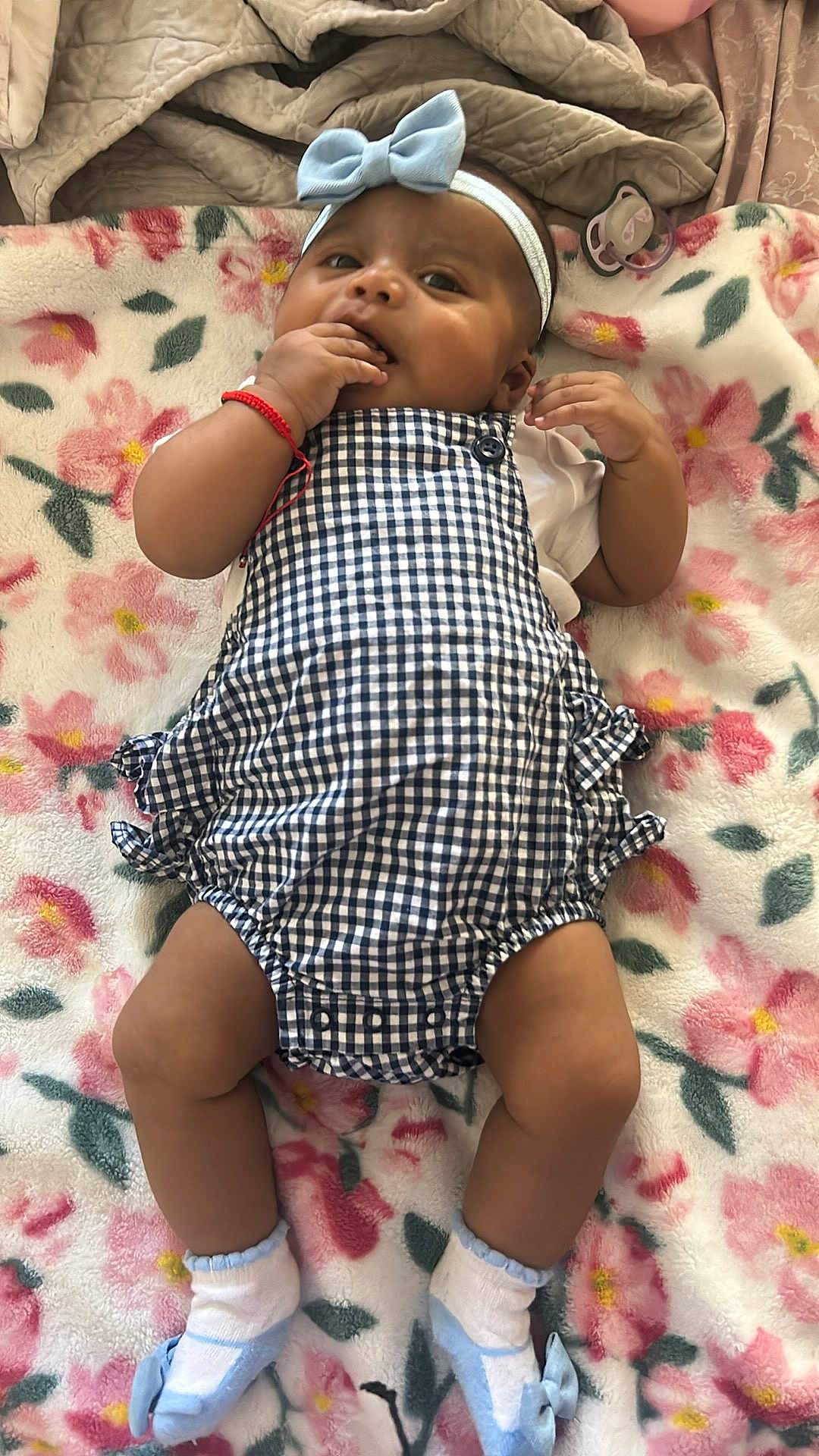 Angie joined the competition — help win amazing prizes! baby, infant, child, romper, headband, blue_bow, blanket, floral_pattern, sock, lying_down, pacifier, hand_in_mouth, cute, indoors, soft_texture, cozy, skin, expression, comfortable, clothing