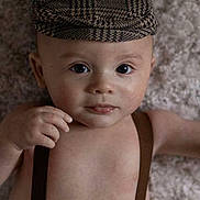 Mylan participe au concours pour gagner de l'argent avec cette photo : baby, child, face, hat, suspenders, skin, portrait, infant, cute, expression, lying_down, looking_at_camera, indoors, soft_light, texture, blanket, closeup, one_person, headwear, human