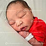 newborn, baby, sleeping, infant, red_clothing, pillow, hospital_wristband, face, closed_eyes, skin, head, peaceful, portrait, young_child, resting, indoors, blanket, cute, human, watermark