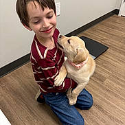 Shelby joined the competition — help win amazing prizes! affection, blue_jeans, boy, casual_clothing, child, collar, cute, dog, embrace, floor, happy, indoor, kneeling, light_wall, pet, puppy, short_hair, smiling, striped_shirt, wooden_floor