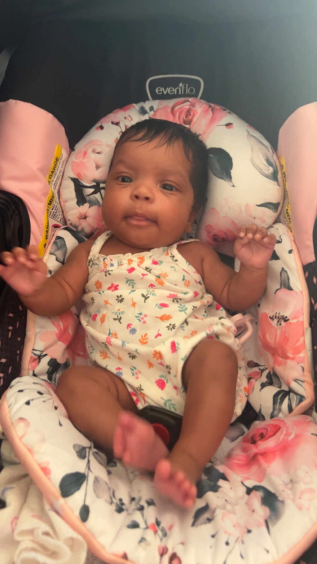 Zoie joined the competition — help win amazing prizes! baby, infant, child, car_seat, floral_pattern, clothing, person, face, arms, legs, pink, white, comfort, relaxation, indoors, cute, young_child, seat, portrait, infant_clothing