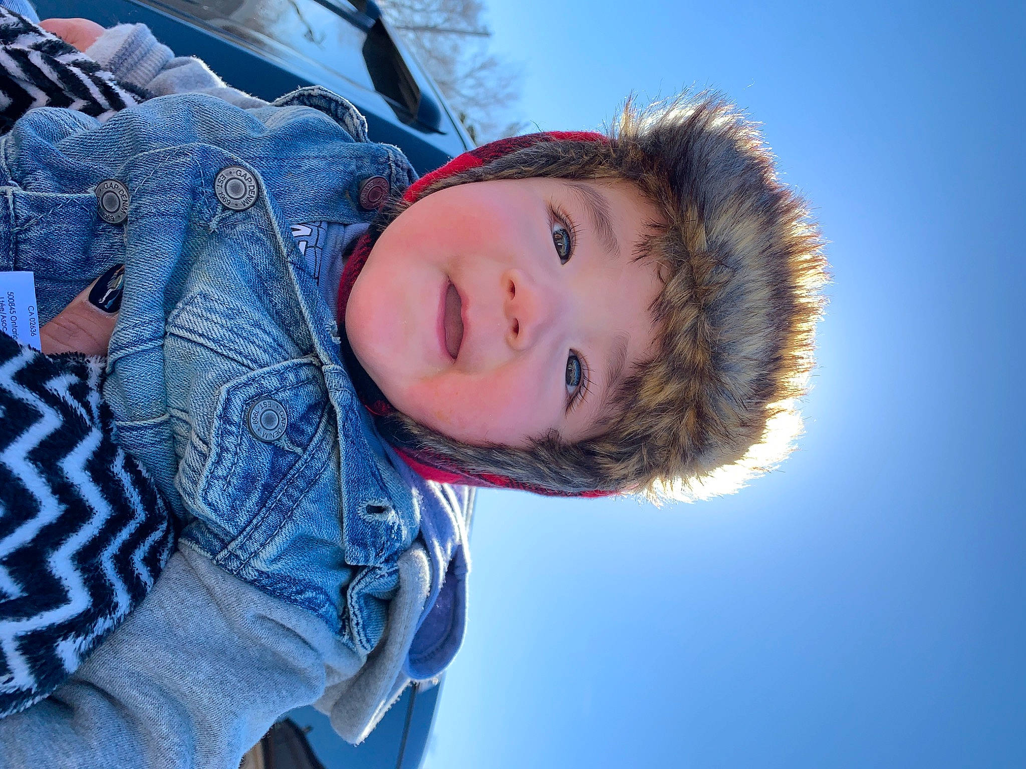 Kayleb is registered to the contest to win money with this photo: azure, black_hair, blue, child, cloud, cool, denim, electric_blue, face, flash_photography, freezing, fun, fur, happy, person, portrait_photography, sky, smile, snow, tree
