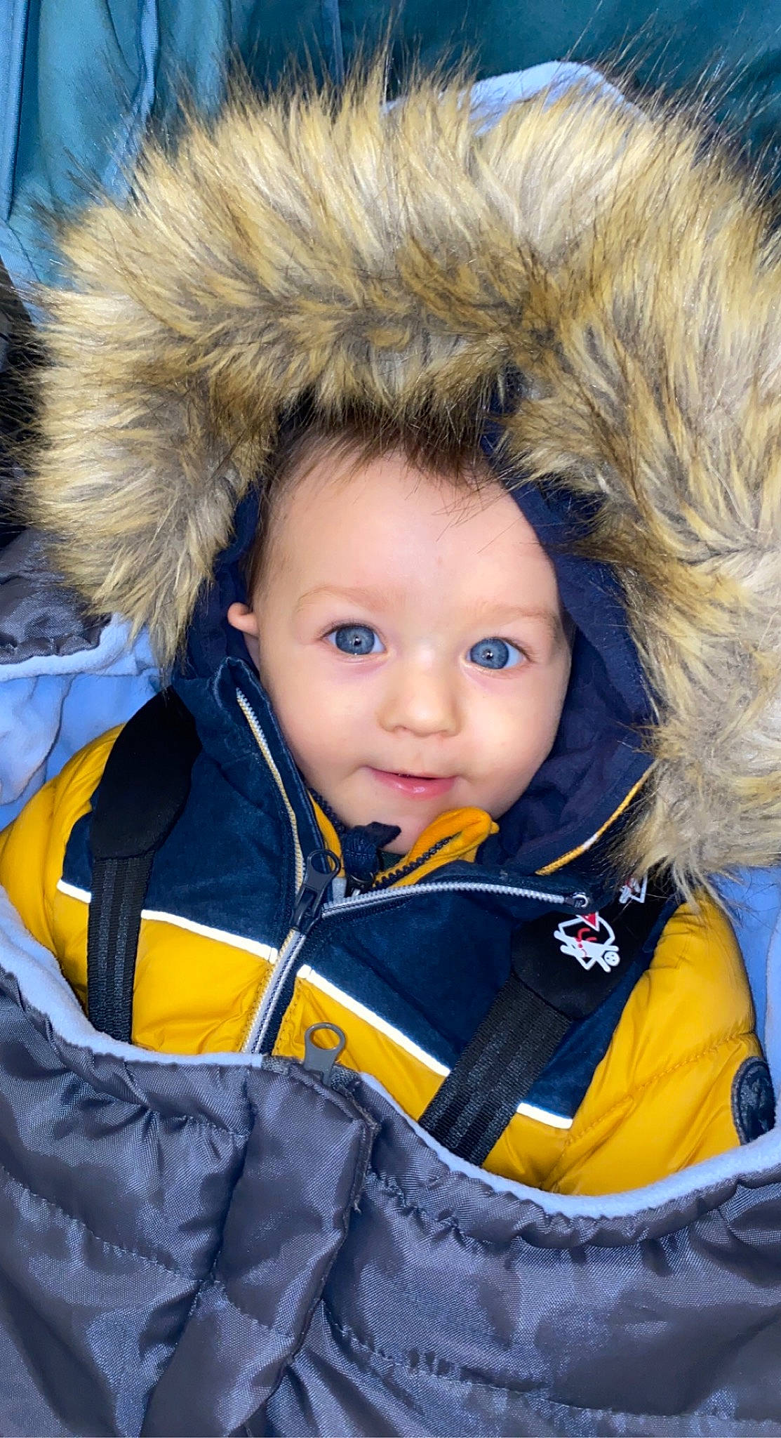 Sasha participe au concours pour gagner de l'argent avec cette photo : cap, cheek, chin, electric_blue, eye, eyebrow, face, fur_clothing, hairstyle, happy, hat, iris, jacket, nose, organ, outerwear, parka, person, sleeve, toddler